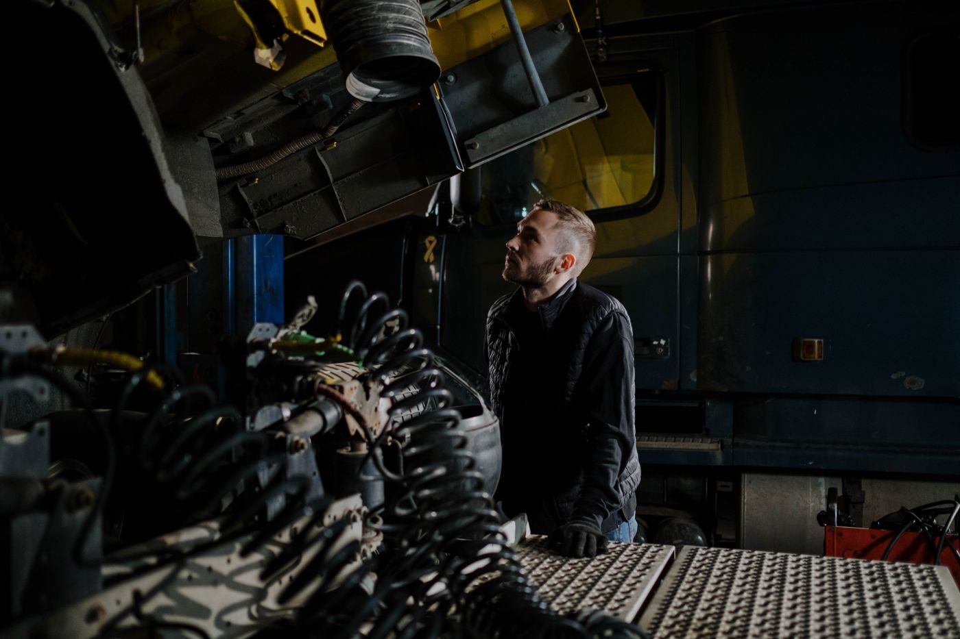 Mechanic inspecting the underside of a heavy-duty semi truck